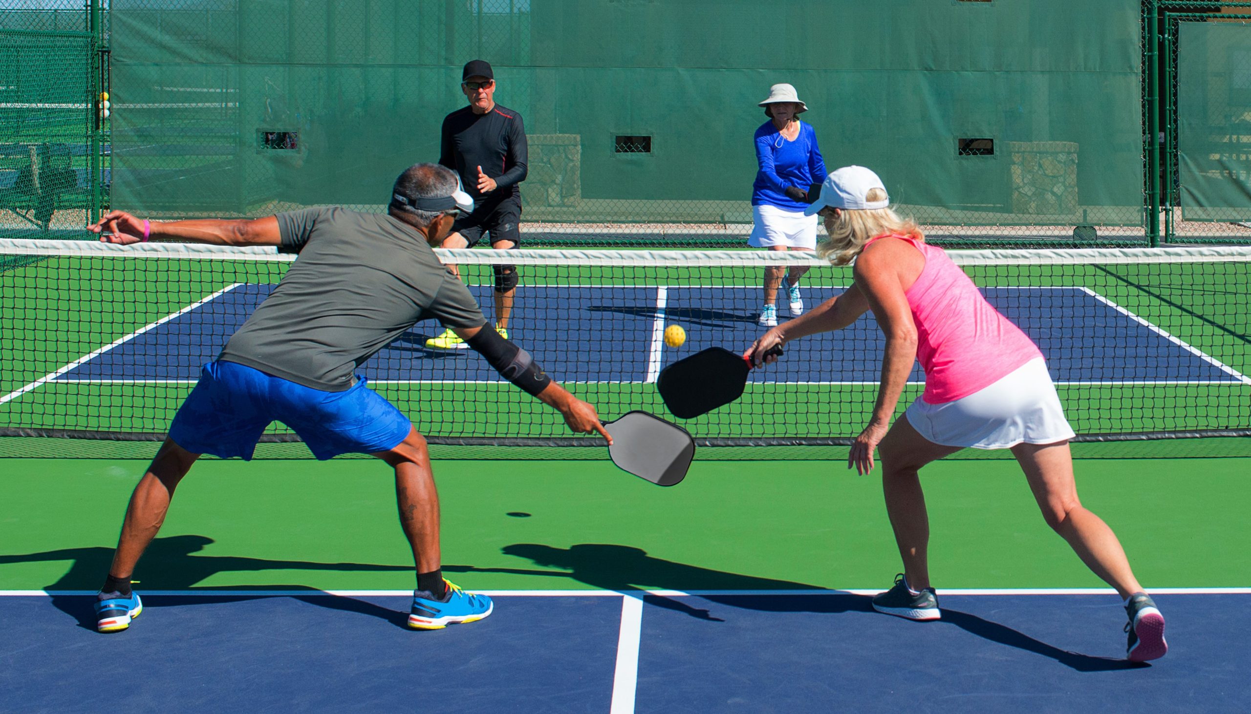 pickleball doubles playing on a colorful court