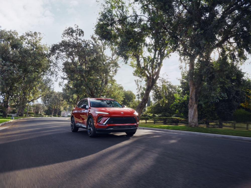 Buick Envision driving down tree lined street