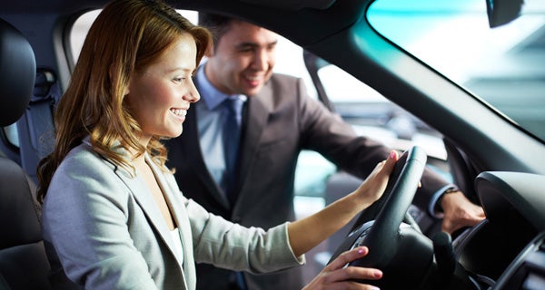 Salesman helping show business woman a car