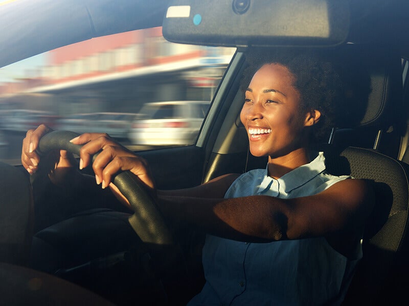 woman driving car and smiling